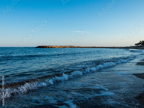 Sea view with waves on the beach at sunset