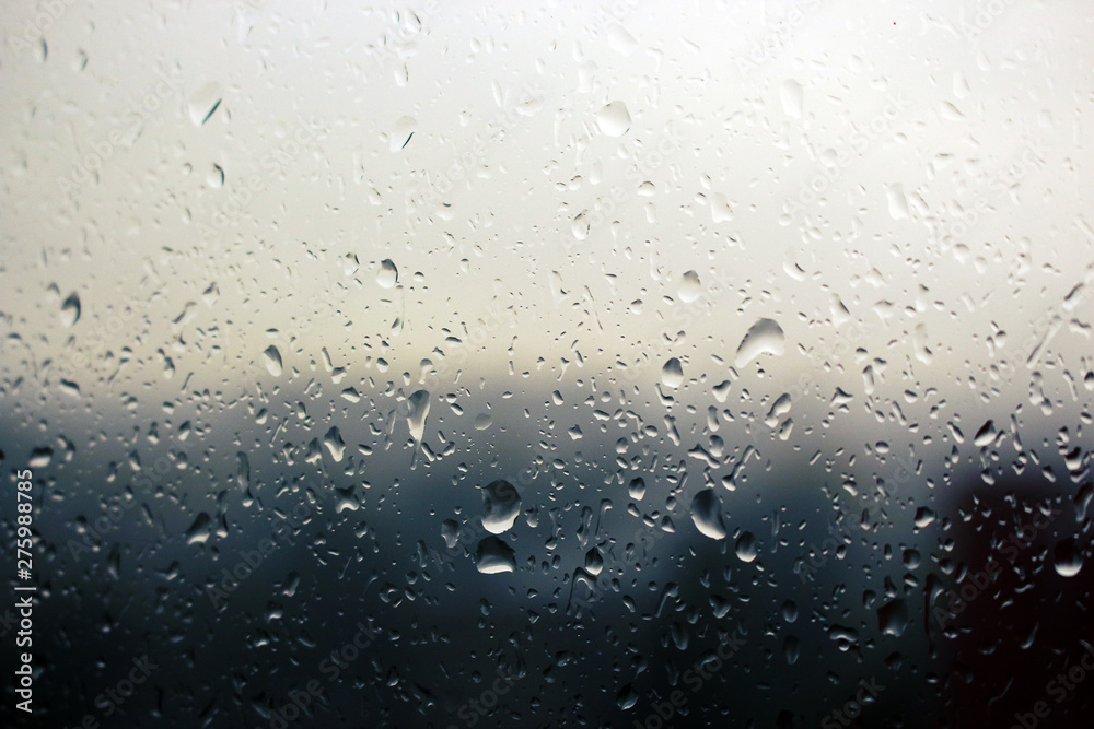 Big raindrops on window glass in stormy weather