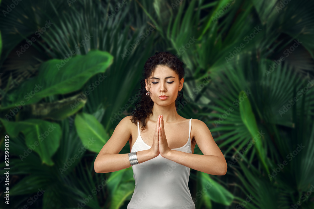 Woman meditating in tropical rainforest. Woman meditating in tropical rainforest.