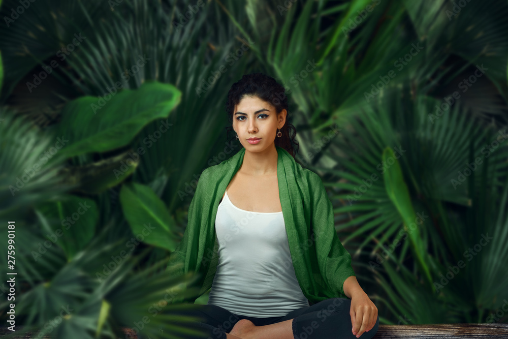 Woman meditating in tropical rainforest. Woman meditating in tropical rainforest.