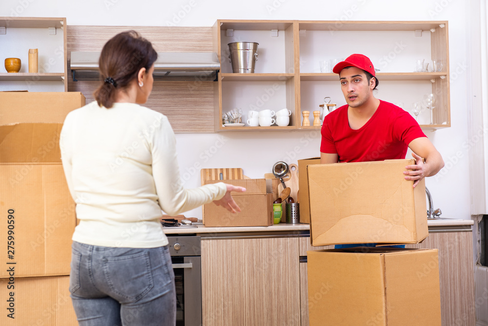 Young male contractor and female customer in moving concept  