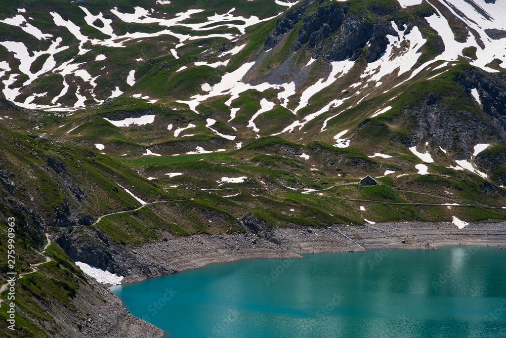 Schneebedeckte Berge im Sommer mit kristallklarem Wasser