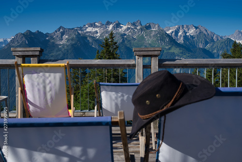 Panoramablick auf die Alpen mit Sonnenstühlen photo