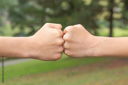 Two children's fists hit each other in the forest and the park © Pavel Iarunichev