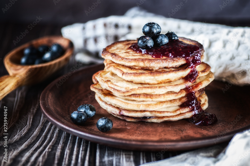 Pancakes with blueberry and honey. On a wooden table with a white towel Pancakes with blueberry and honey. On a wooden table with a white towel