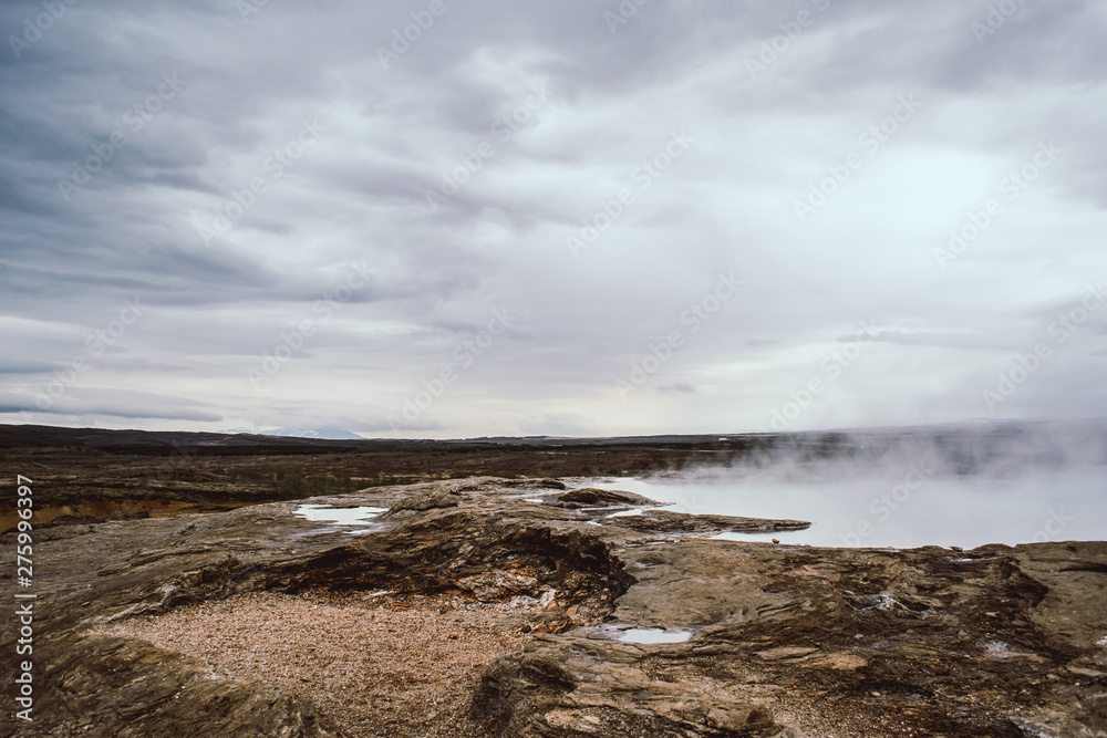 Endless Icelandic landscapes. Pale white geyser steam and clouds on the horizon