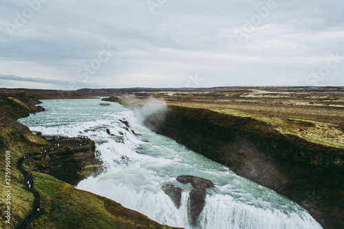 Bright white waters of Gullfoss in Iceland. Groups of tourists admiring the view © Yurii Zymovin