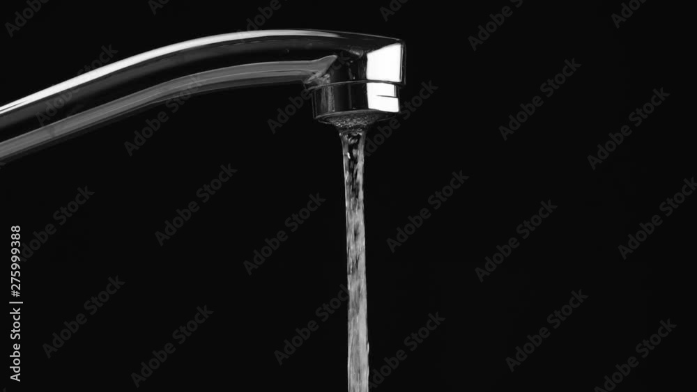 water flows from the tap on a black background, then the water stops