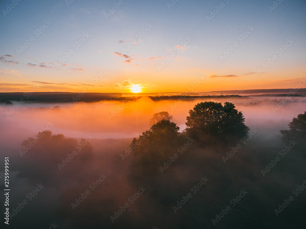 Sunrise over spring meadow. Spring aerial landscape. Spring sunrise over green forest and field with river and fog.