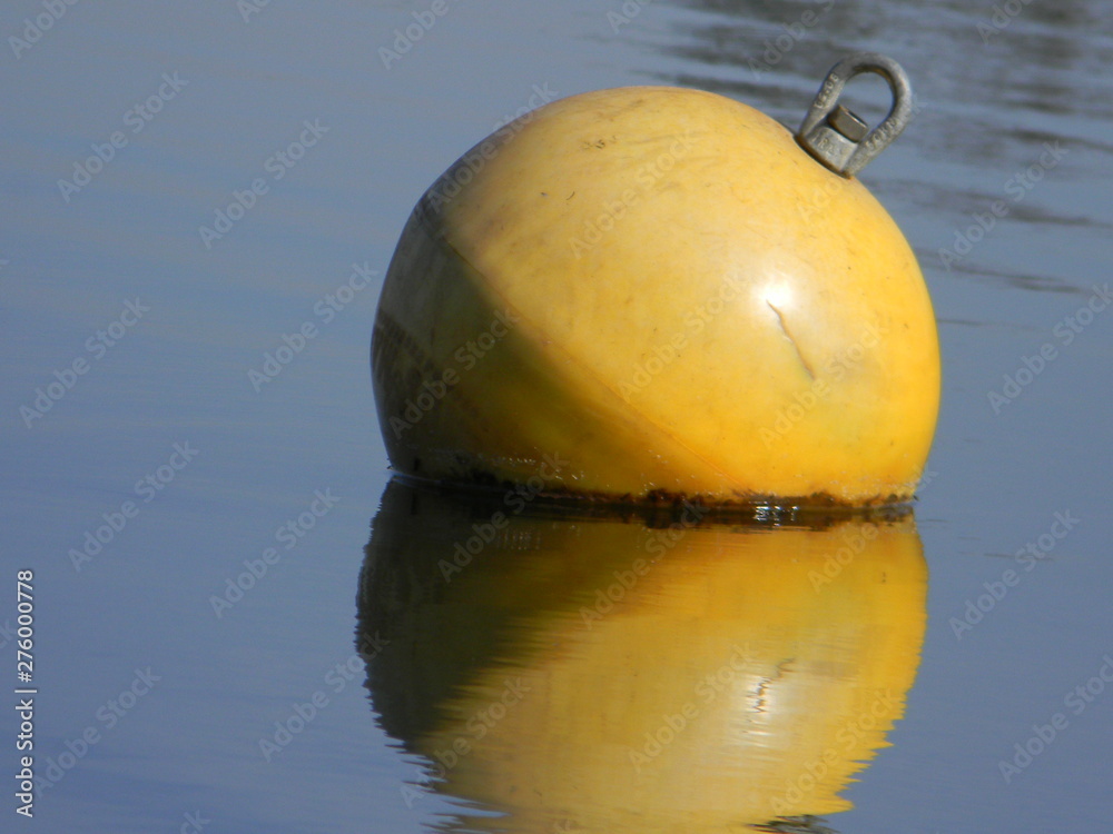 Yellow water buoy floating on calm lake Yellow water buoy floating on calm lake