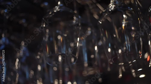 Close-up view of clean washed and polished glasses for wine and other alcoholic drinks hanging over the bar counter. Frame. Decoration,Interior,design concept photo