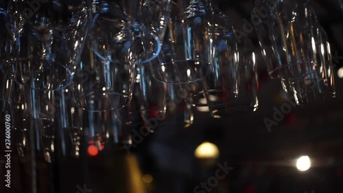Close-up view of clean washed and polished glasses for wine and other alcoholic drinks hanging over the bar counter. Frame. Decoration,Interior,design concept photo