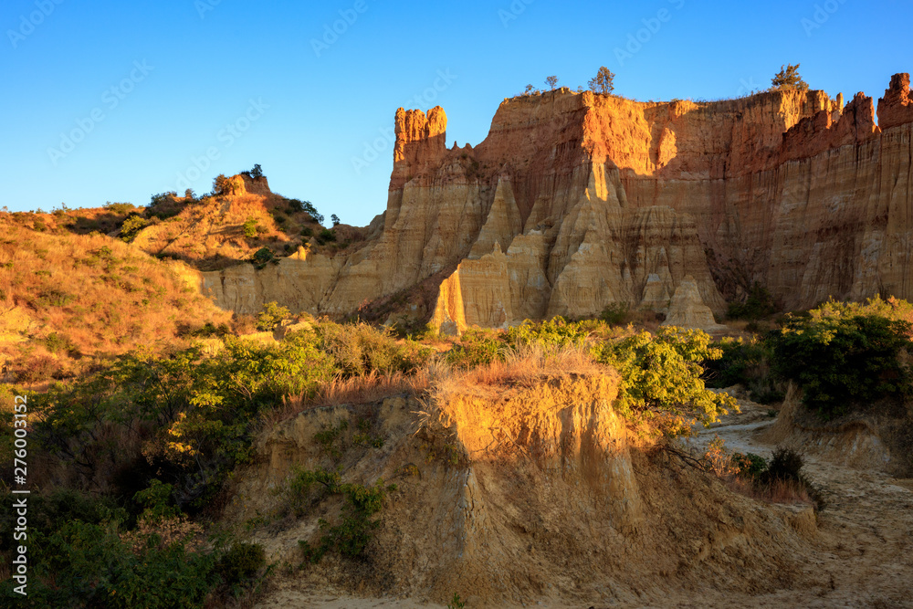 Earth Forest of Yuanmou in Yunnan Province, China - Exotic earth and sandstone formations glowing in the sunlight. Naturally formed pillars of rock and clay with unique erosion patterns. China Travel