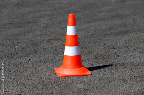 An orange traffic cone on the asphalt road