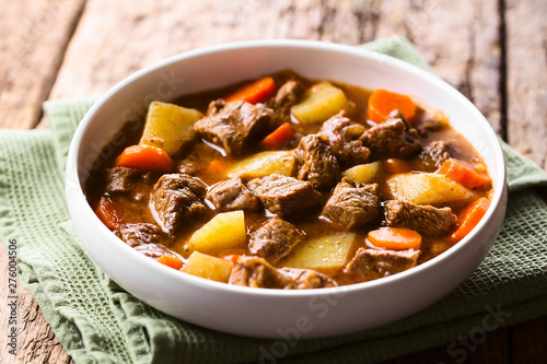 Fresh homemade beef stew with carrot and potatoes served in bowl (Selective Focus, Focus in the middle of the image) photo