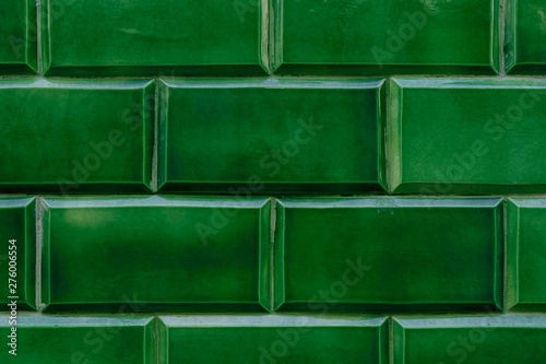 Detail of a ceramic wall in intense green color. Detail of a ceramic wall in intense green color. Traditional Portuguese and Spanish ceramics.