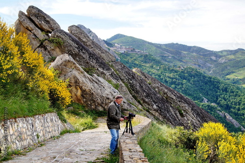 A photographer in the beautiful Lucan Dolomites. Castelmezzano, Basilicata. Italy  T photo