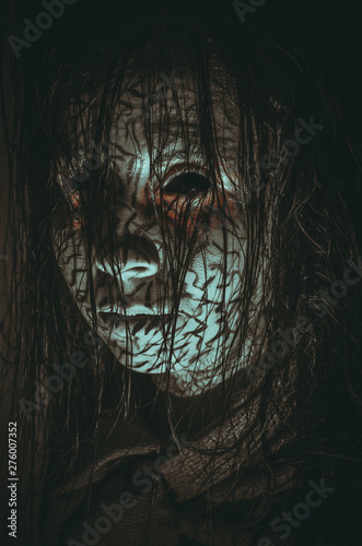 Demonic girl with black eyes and cracked skin close-up portrait