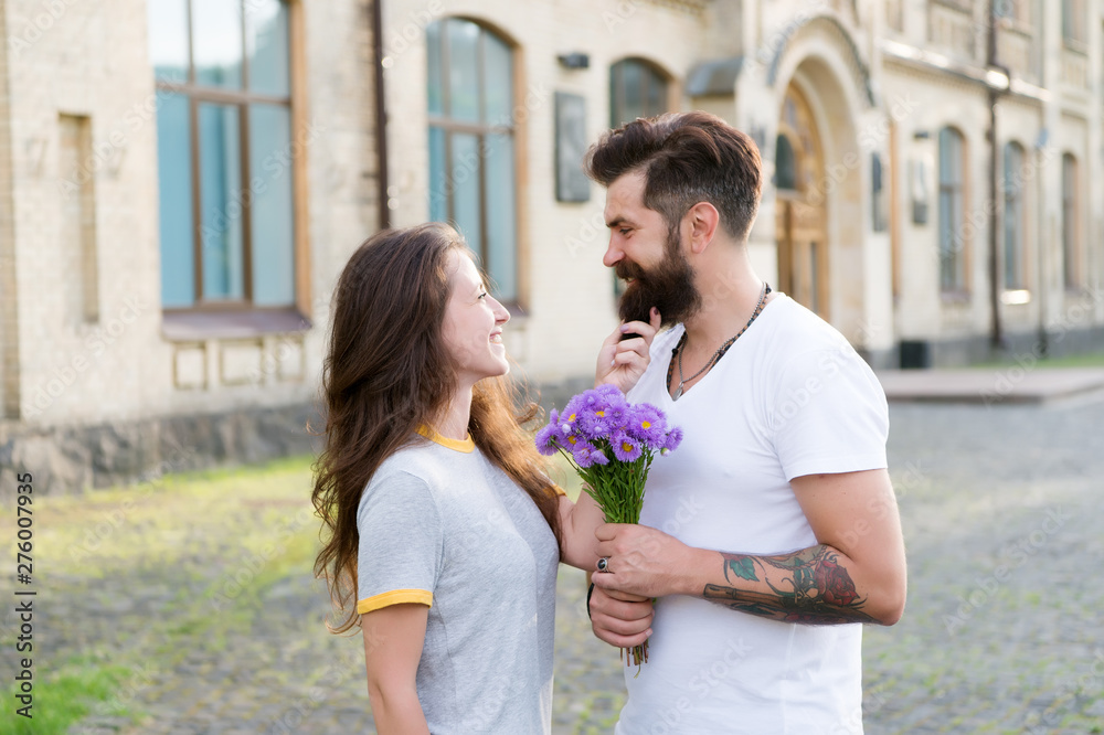 Naklejka premium True feelings. Pick up girl for date. Bearded hipster fall in love. Couple meeting for date. Bouquet gift. Man giving flower bouquet. Romantic date. Guy prepared surprise bouquet for girlfriend