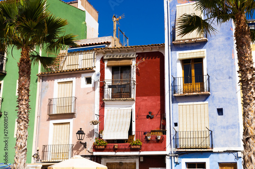 Closeup facades of colorful houses and palm trees on the street of the old village of Villajoyosa, Costa Blanca, Spain photo