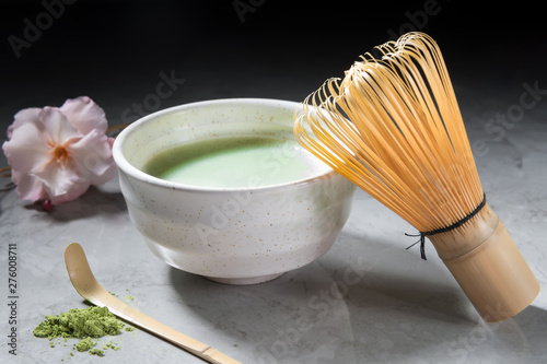 Green matcha tea drink and tea accessories on grey marble background. Japanese tea ceremony concept