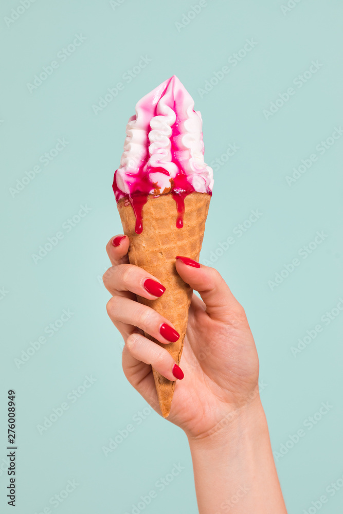 Female hand holding ice cream in waffle cone Female hand holding ice cream in waffle cone