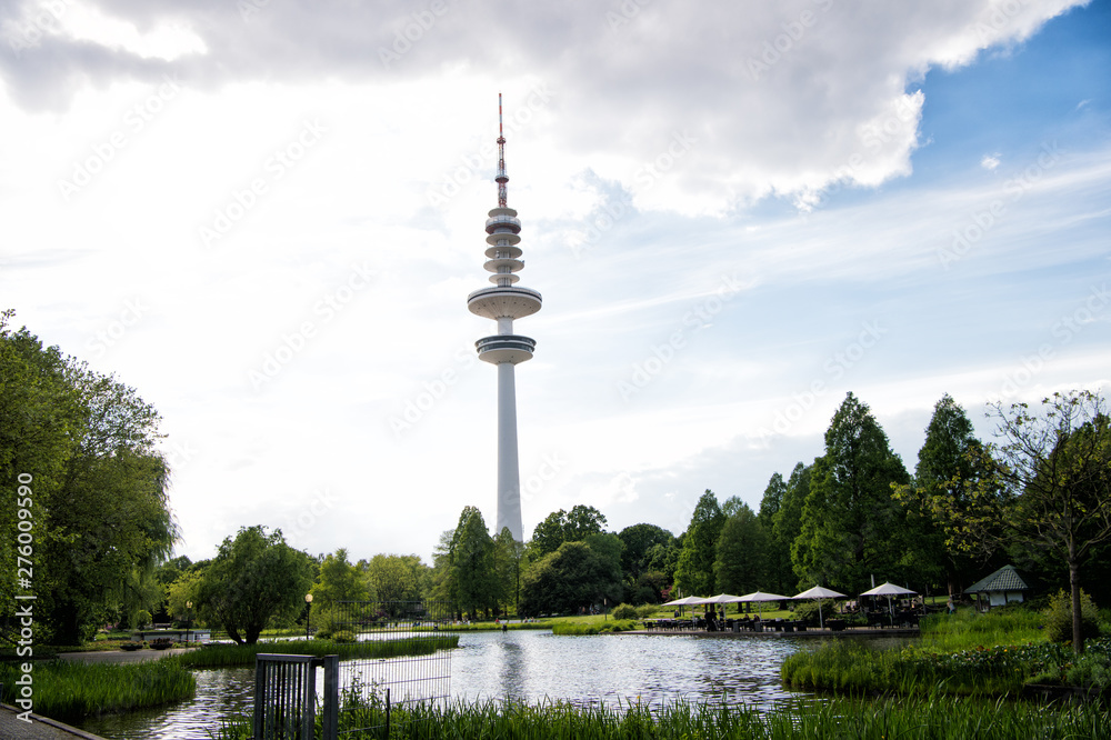 Fototapeta premium Sending and receiving waves. Tower or radio mast. TV tower on urban landscape. Tall tower supporting transmitting antenna. Tower structure for telecommunications and broadcasting