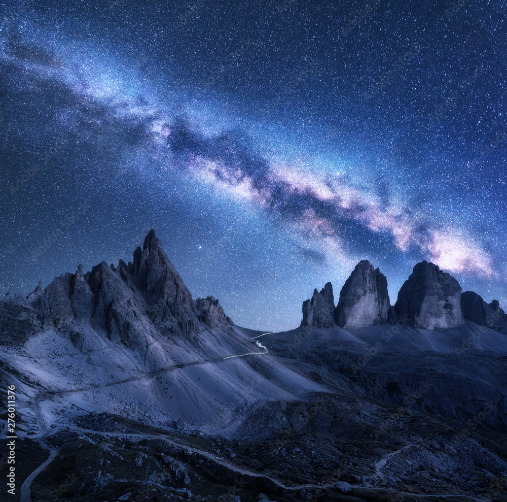 Milky Way over mountains at starry night in summer. Amazing landscape with alpine mountains, blue sky with milky way and stars, high rocks. Tre Cime in Dolomites, Italy. Space. Beautiful nature
