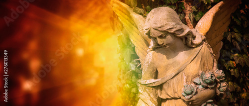 Foto Ancient statue of guardian angel in sunlight.