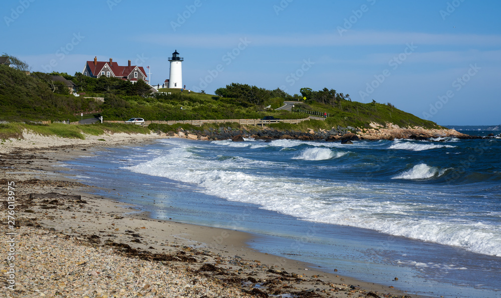 heavy surf at the ocean shore with a view of Nobska Light lighthouse