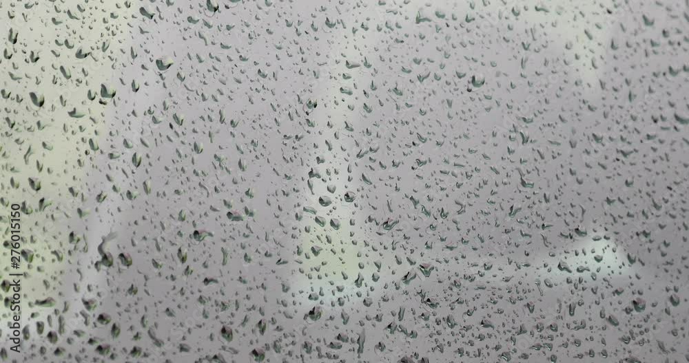 Rain water drops flowing on car glass window. Selective focus used. Rain water drops flowing on car glass window. Selective focus used.