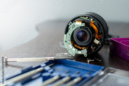 the broken lens lies on the repair stand with the tools, replaces the broken photographic equipment, copy the space
