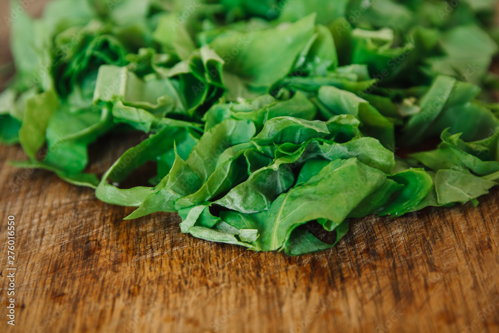 Fresh bright green spinach on a wooden board. Chopped spinach as a background. Fresh bright green spinach on a wooden board. Chopped spinach as a background.
