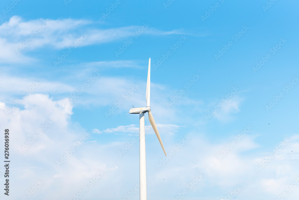 The wind turbine power working, blue sky, energy power concept The wind turbine power working, blue sky, energy power concept