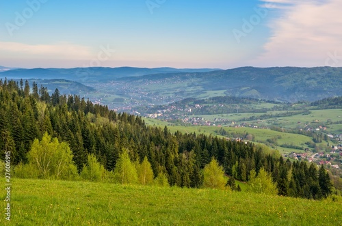 Beautiful spring mountain landscape. Green meadows and valleys between the hills. © shadowmoon30