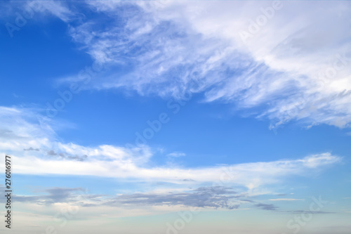 White cirrus and stratus clouds high in the blue summer sky. Different cloud types and atmospheric phenomena. Skyscape.