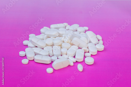 white medicine pill on liht pink background