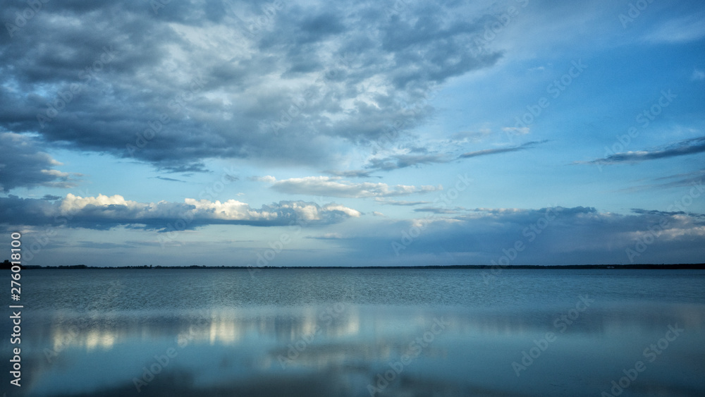 Beautiful blue background. Clouds reflected on the water. Switiaz Lake. Polesie. Ukraine