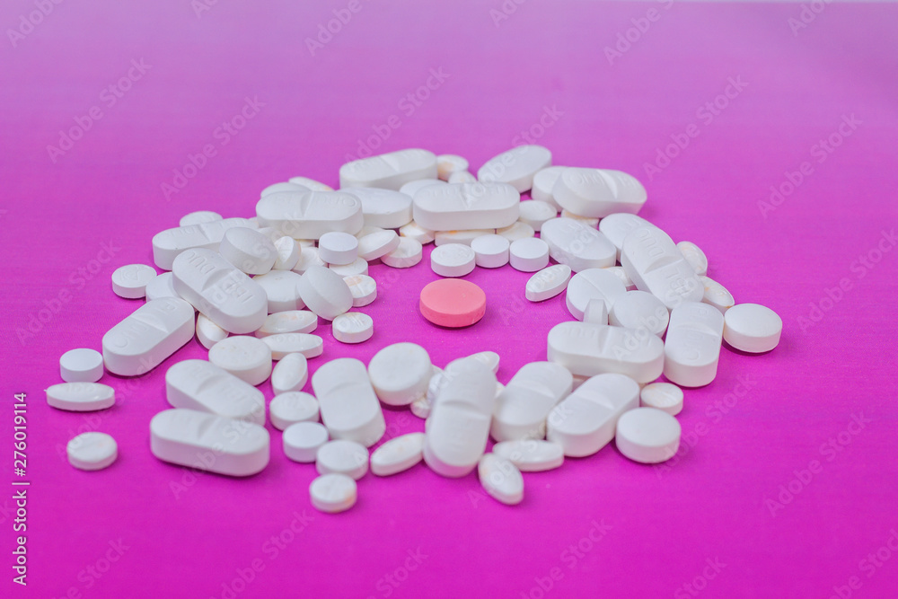 white medicine pill on liht pink background and pink in the center white medicine pill on liht pink background and pink in the center