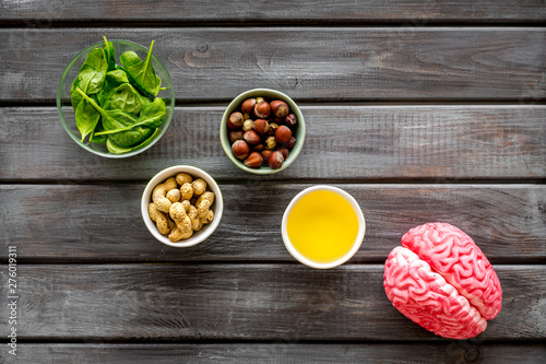 Brain food concept with peanut, hazelnut, seed-oil, spinage on wooden background top view photo