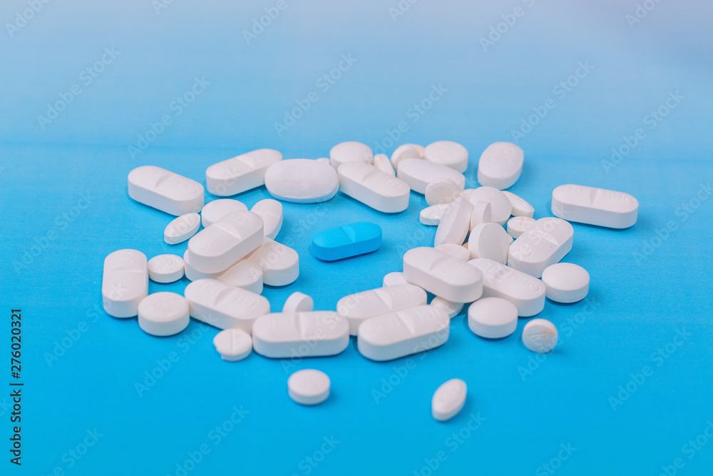 white medicine pill on liht blue background and blue in the center white medicine pill on liht blue background and blue in the center