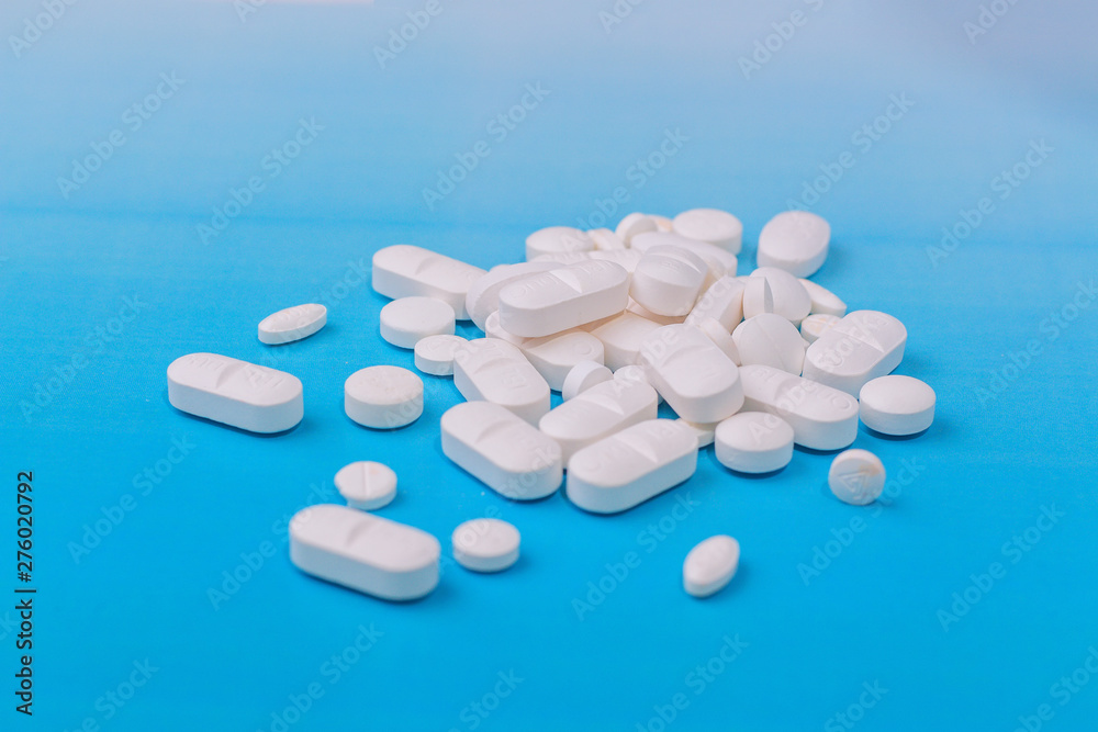 white medicine pill on liht blue background