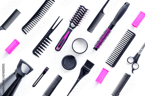 Combs, sciccors and pink hairdresser tools in beauty salon work desk on white background top view pattern