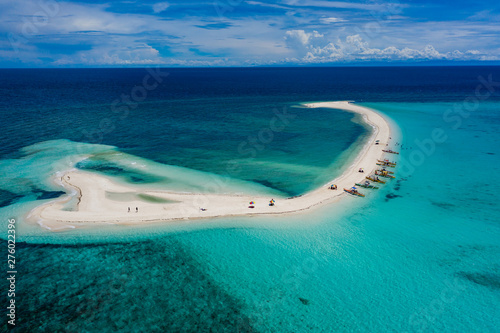 Aerial drone view of a beautiful white sandbar surrounded by coral reef near a tropical island (White Island, Camiguin)