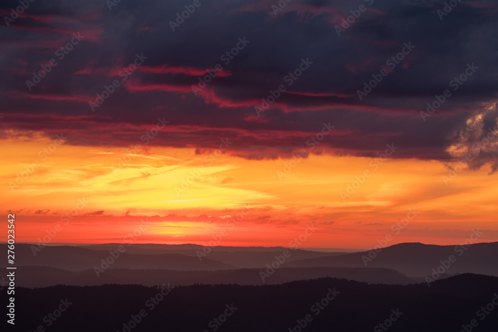 Orange sky, clouds and mountains. Beautiful sunrise in the Bieszczady mountains. Poland