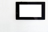 tablet with black case and white blank screen front view on white wall background with copy space for text, display of smart home control device.
