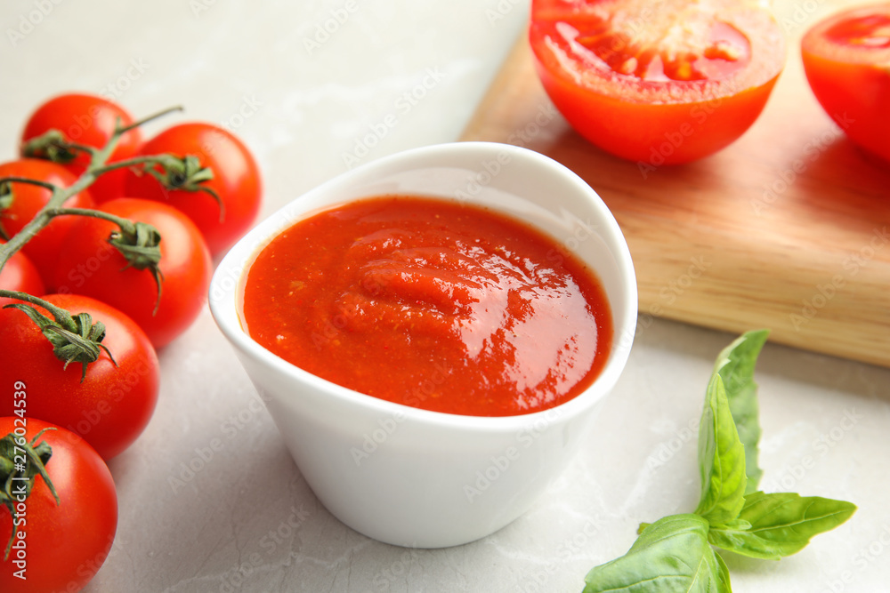 Composition with bowl of tomato sauce on light table Composition with bowl of tomato sauce on light table