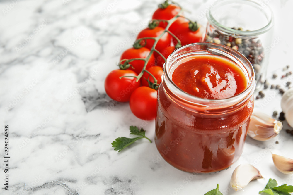 Composition with jar of tasty tomato sauce on marble table. Space for text Composition with jar of tasty tomato sauce on marble table. Space for text