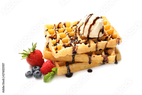 Delicious waffles with berries, ice cream and chocolate syrup on white background