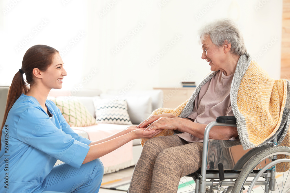 Nurse holding elderly woman's hands indoors. Assisting senior people Nurse holding elderly woman's hands indoors. Assisting senior people